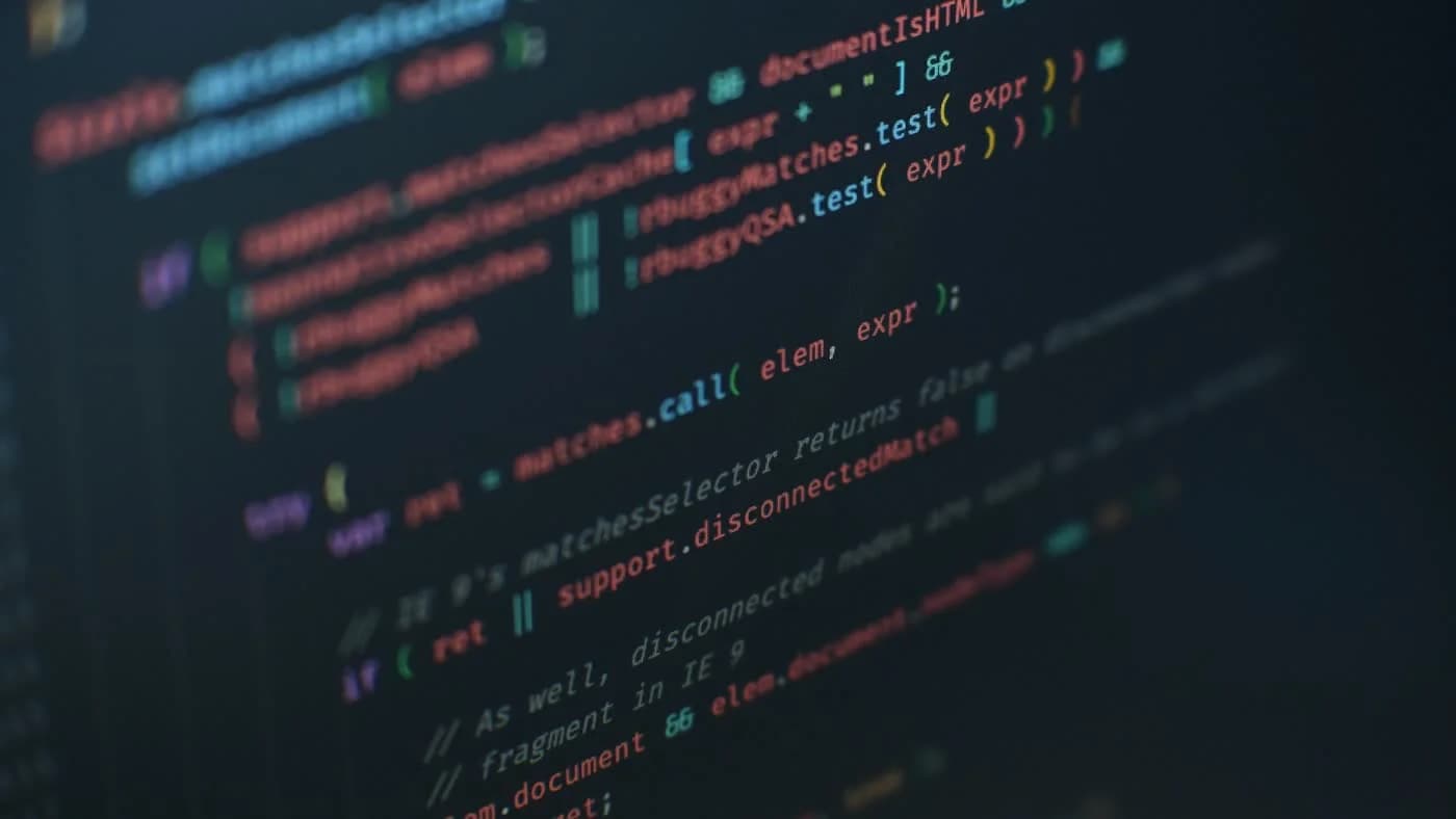 Dark code editor with colorful syntax highlighting representing coding agent API cost comparison