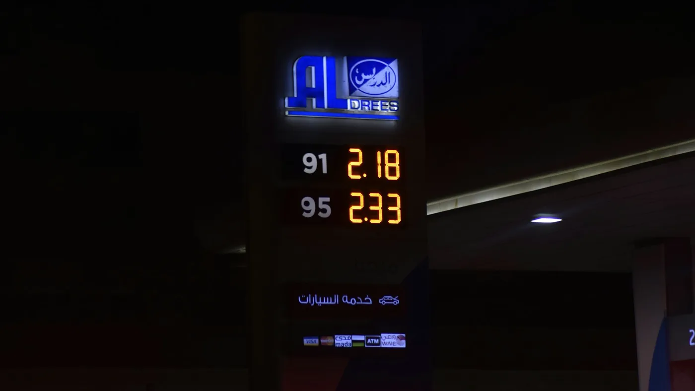 Amber price digits glowing on a fuel price board at night, illustrating LLM API price floors