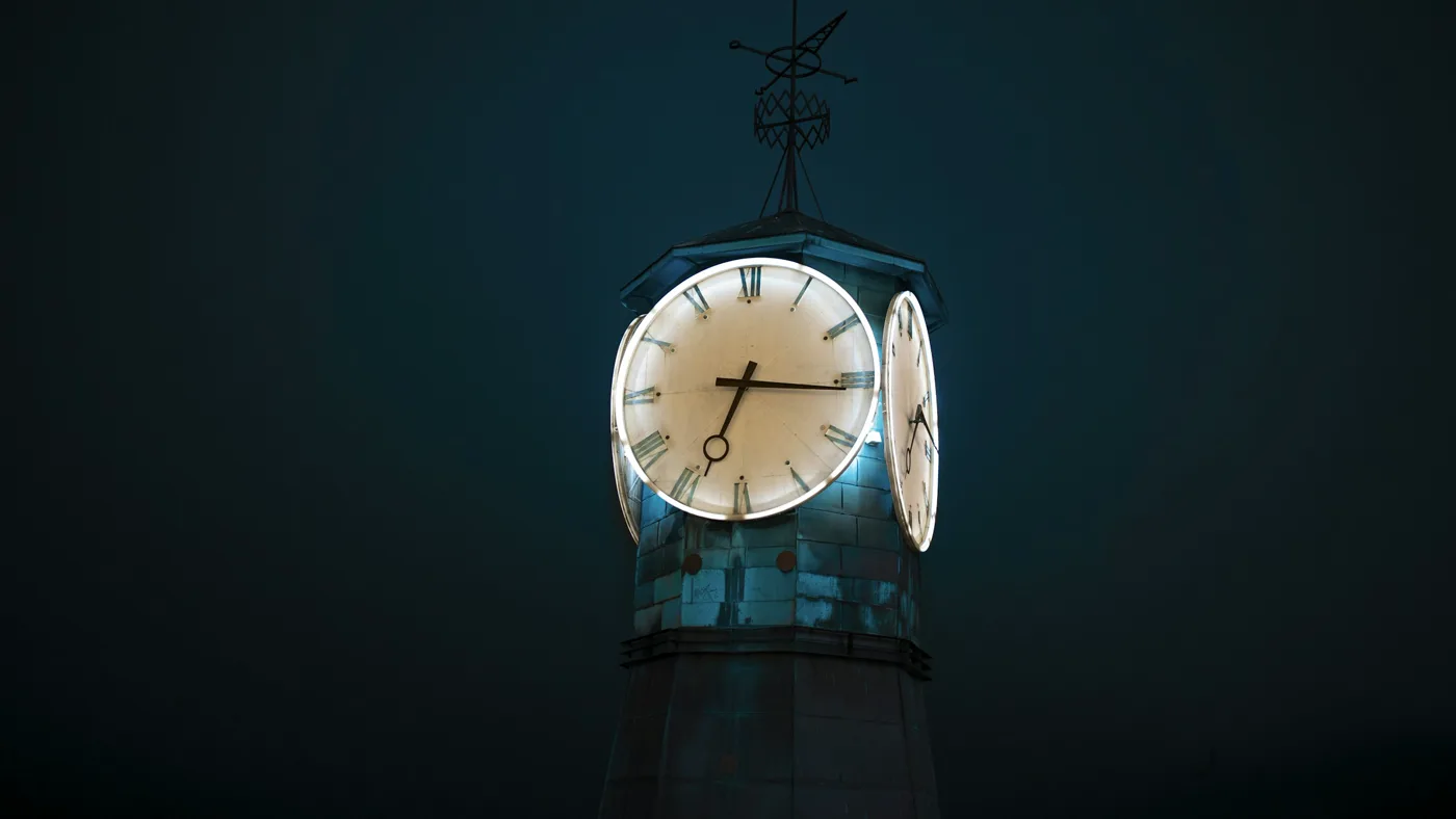 A lit clock tower glowing against a dark winter night, evoking time-of-day API pricing