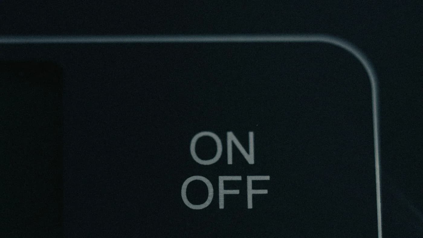 Close-up of a dark panel with the words ON and OFF printed in pale grey inside a rounded outline