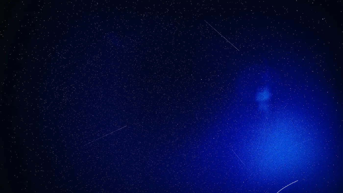Dark blue cosmic field of light streaks, evoking the wait for Google's Gemini 3.5 Pro