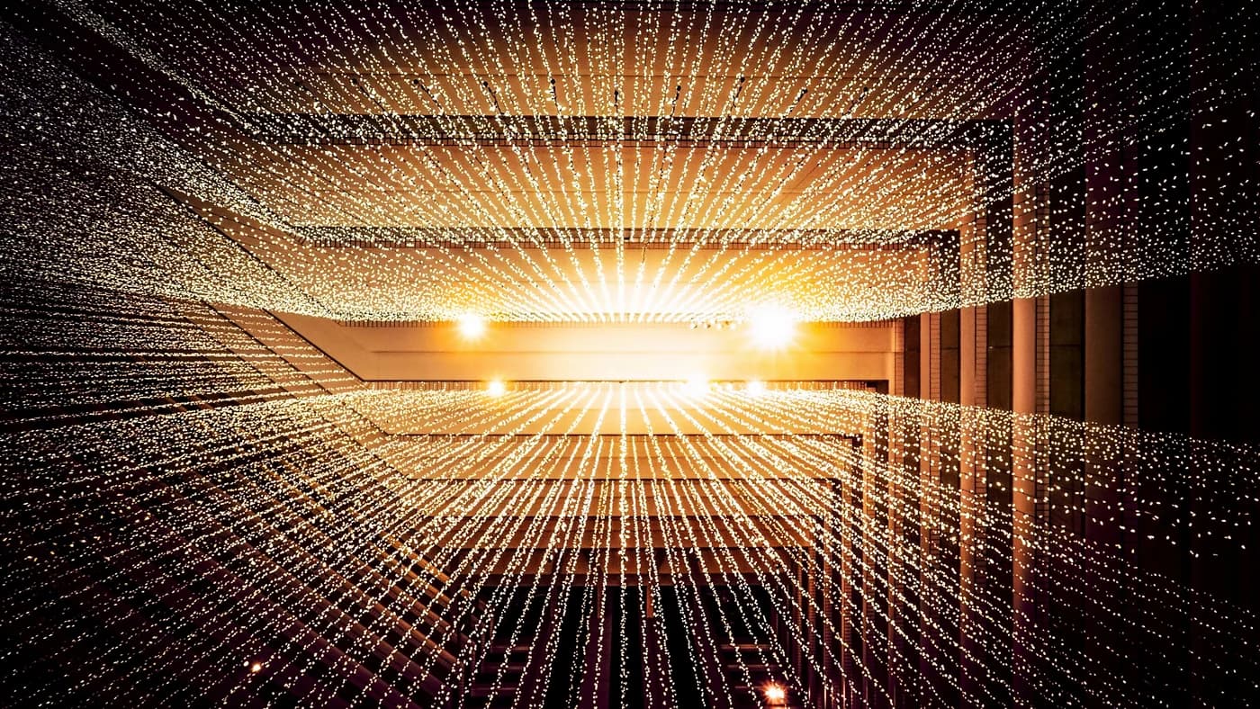 Abstract light tunnel with radiating golden fiber optic lines on dark background
