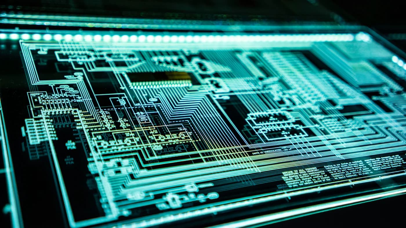 Close-up of a dark circuit board with teal lighting