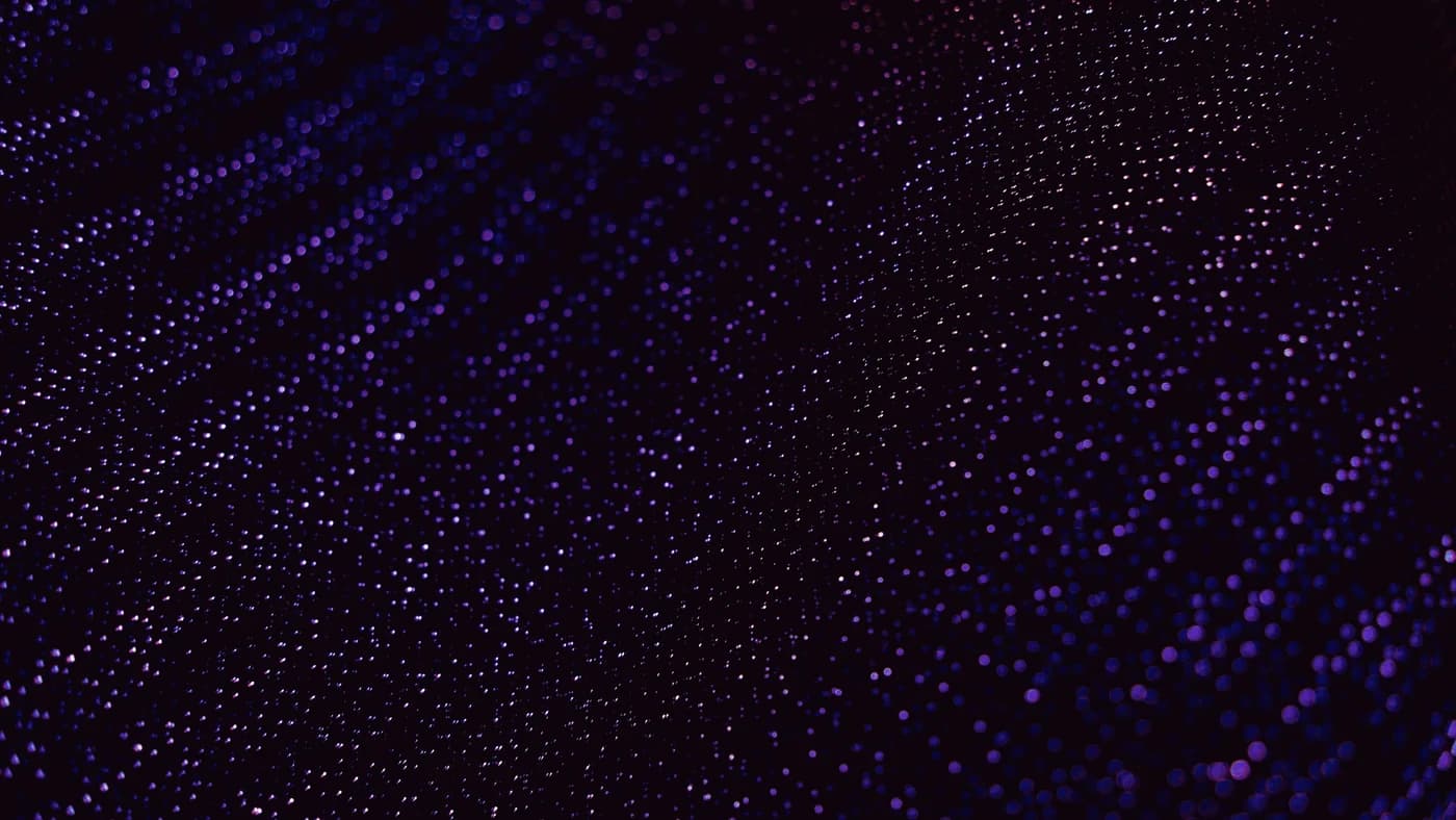 Dense field of blue and violet points of light fading into darkness