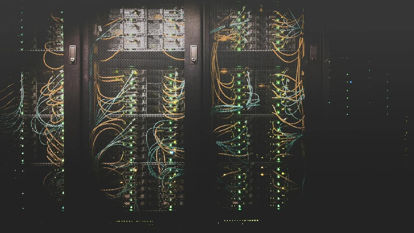 Dark server room with glowing cables representing LLM infrastructure and API pricing