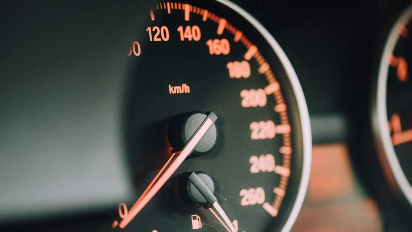 Backlit car speedometer in darkness, illustrating LLM API latency tier pricing