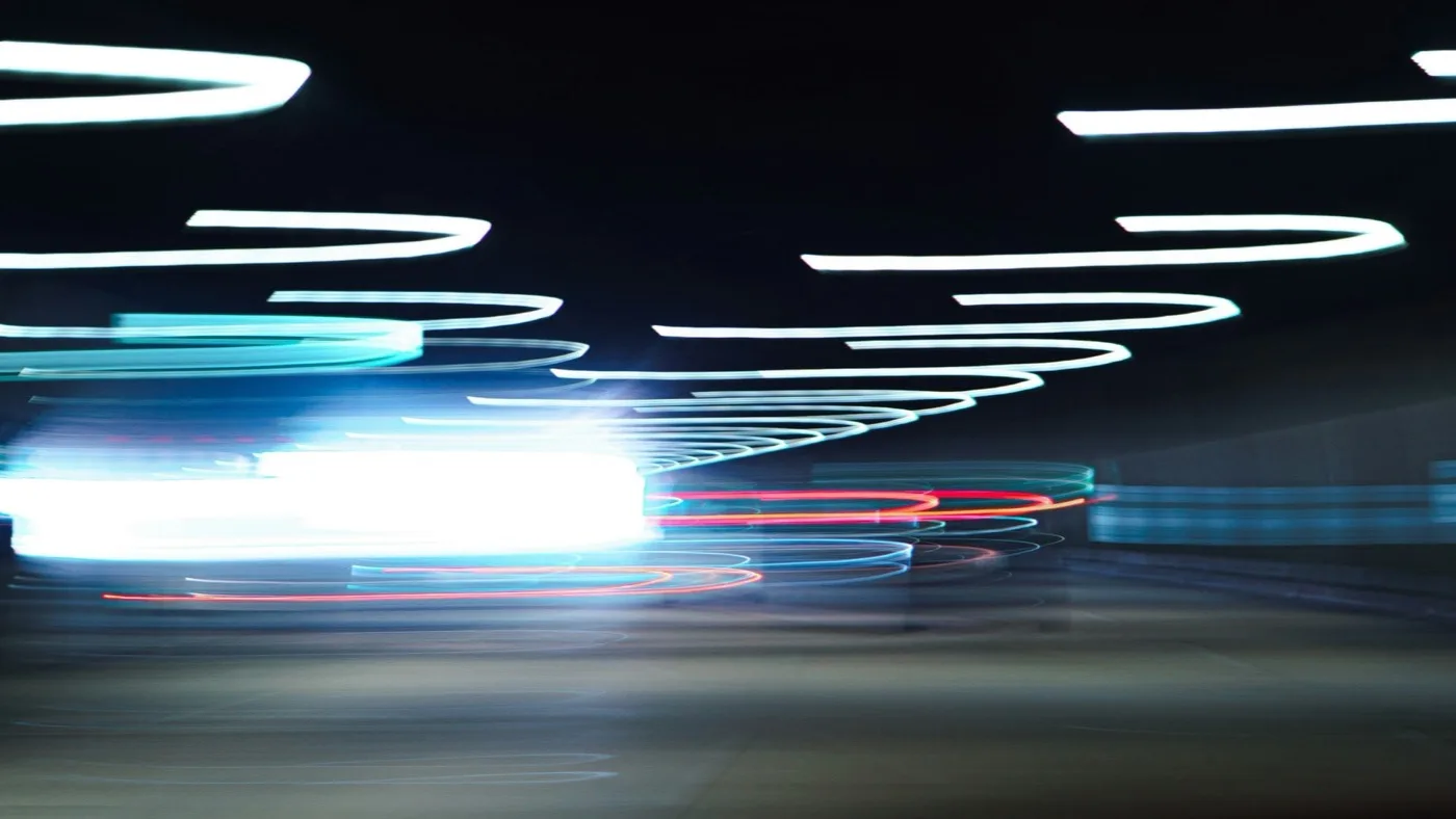 Blue light streaks blurring across a dark background, representing the speed of MAI-Code-1-Flash