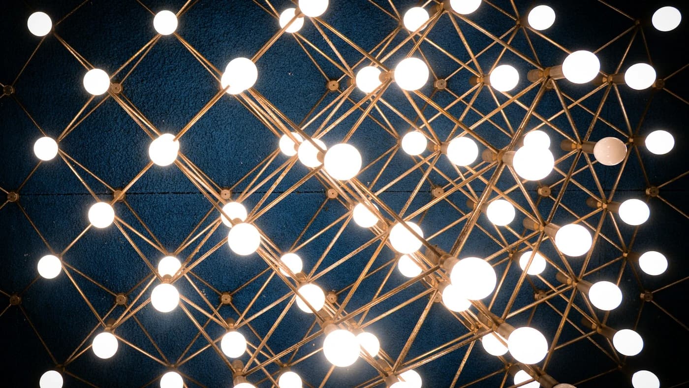Glowing geometric grid of nodes on a dark background representing two competing language models
