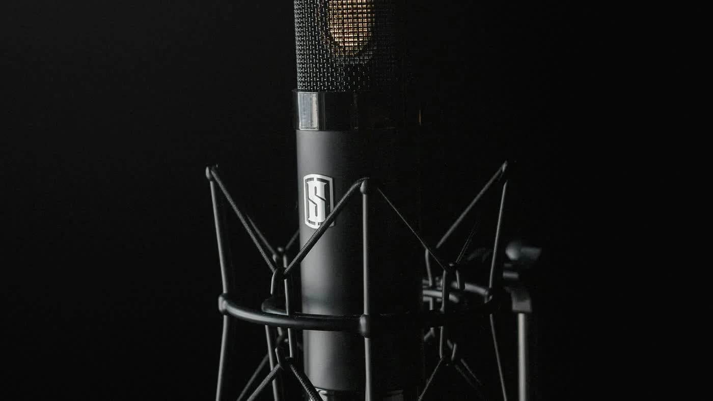 Black condenser studio microphone on dark backdrop representing OpenAI voice model API pricing