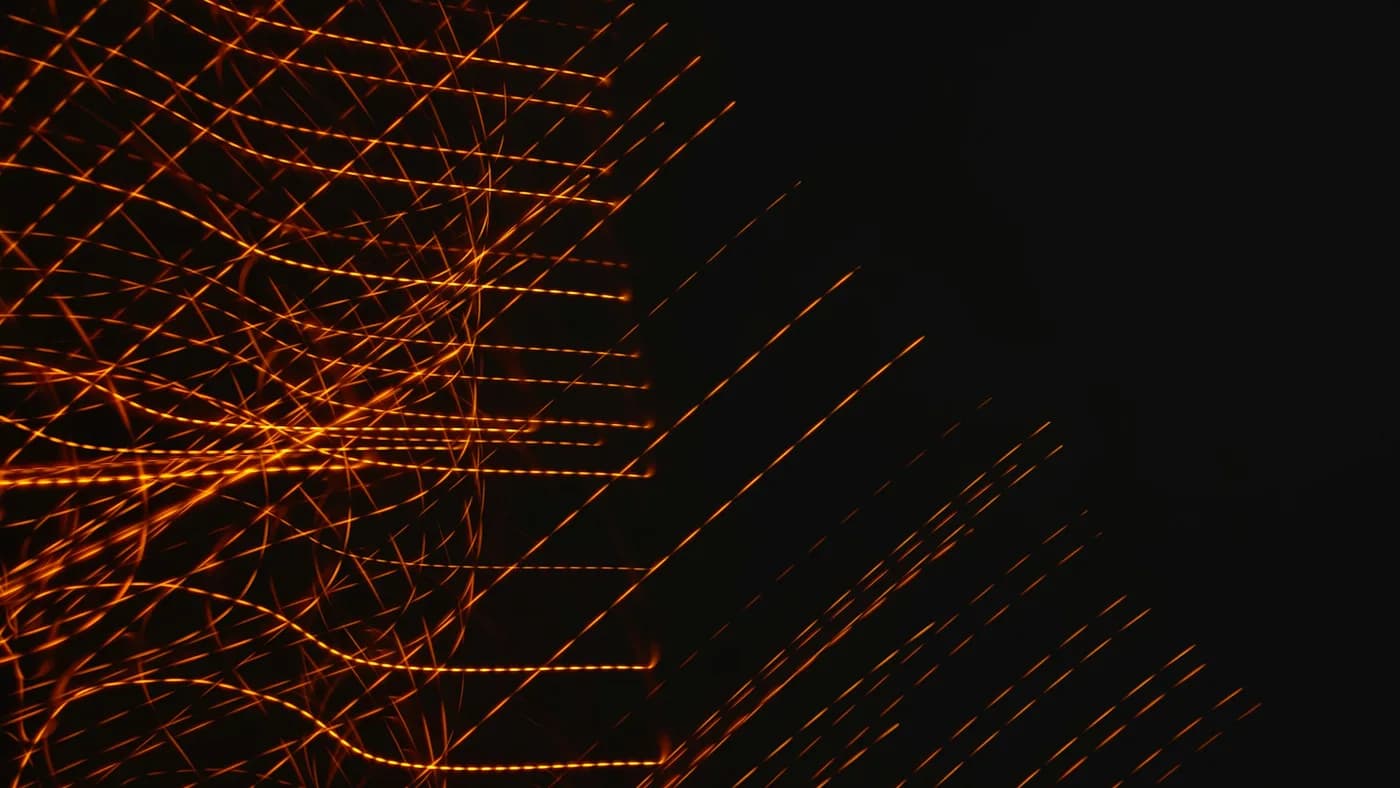 Amber light trails woven into a dense grid on black, suggesting sparse routing through a large network