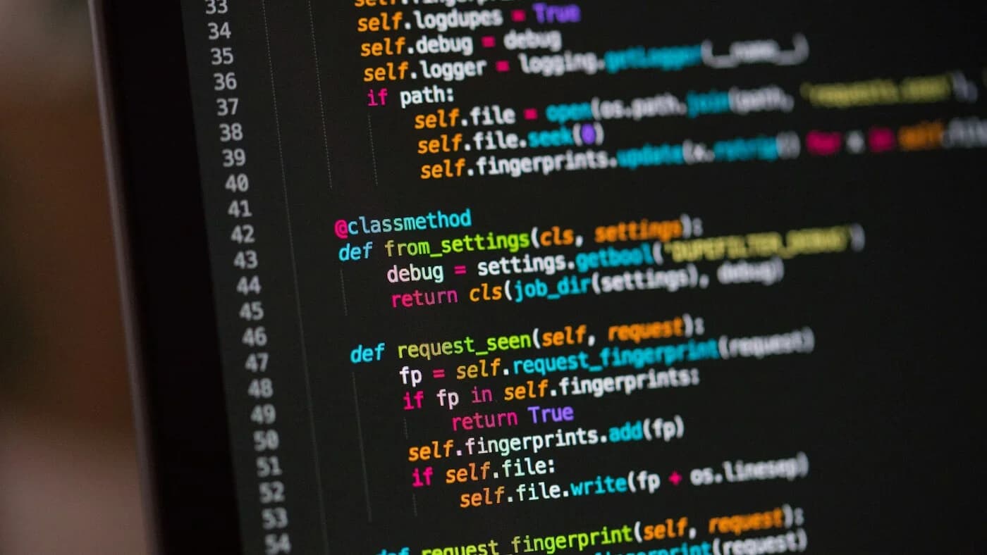 Dark monitor displaying lines of source code, illustrating cheap coding models like Qwen3 Coder Next, Kimi K2.6, GPT-5.5