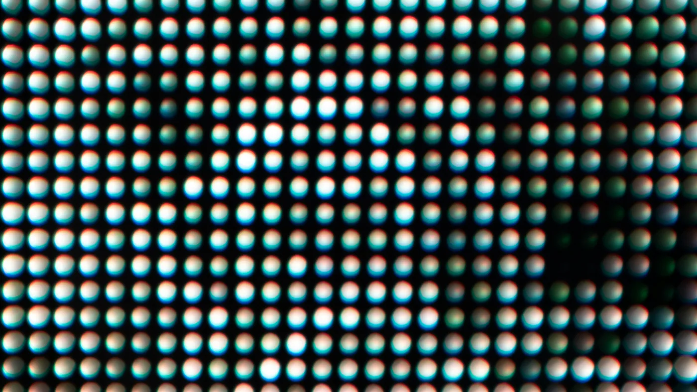 Macro close-up of an LED display panel, its glowing dots forming a dense grid against darkness