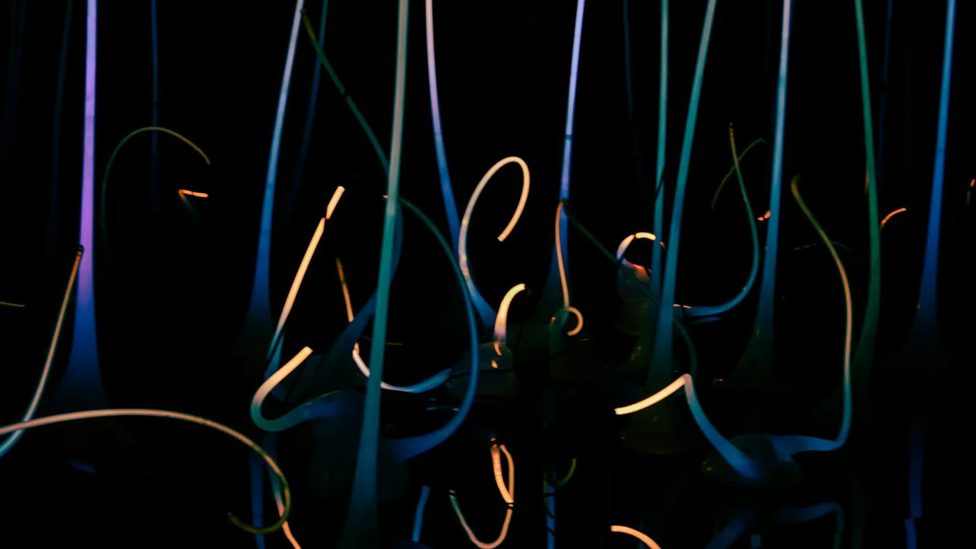 Long-exposure light streaks on a dark background, evoking very high token throughput