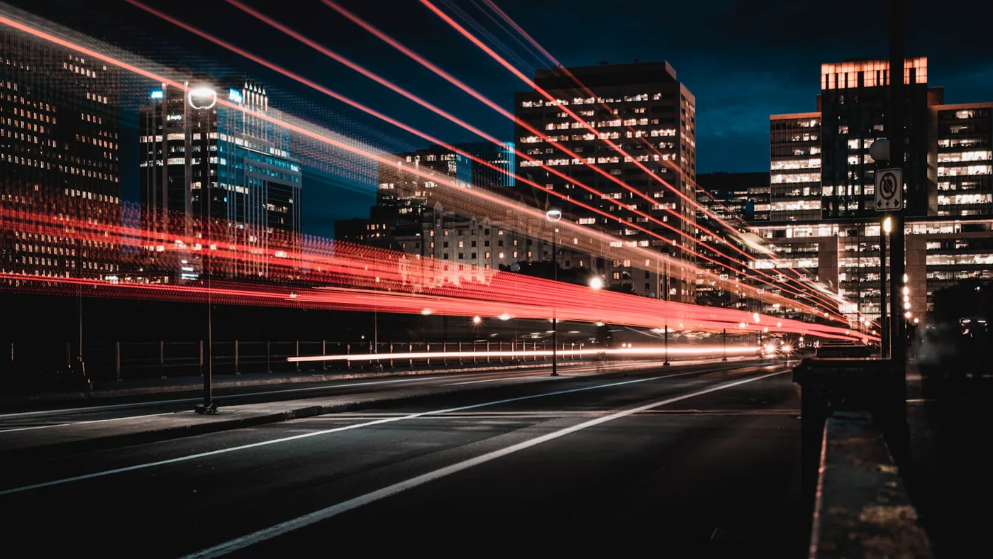 Night highway light trails streaking toward a city, illustrating GPT-5.5 priority processing speed