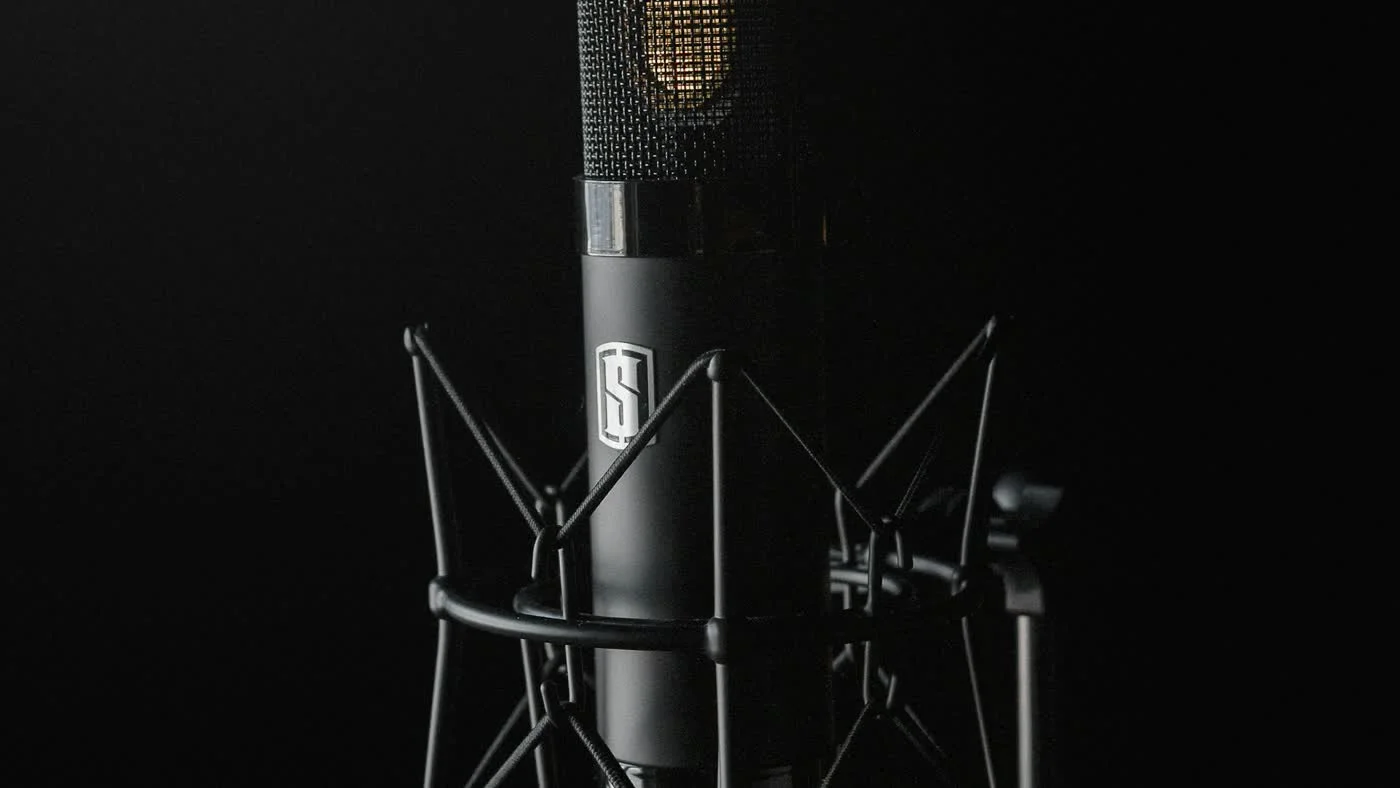 Black condenser studio microphone on dark backdrop representing OpenAI voice model API pricing